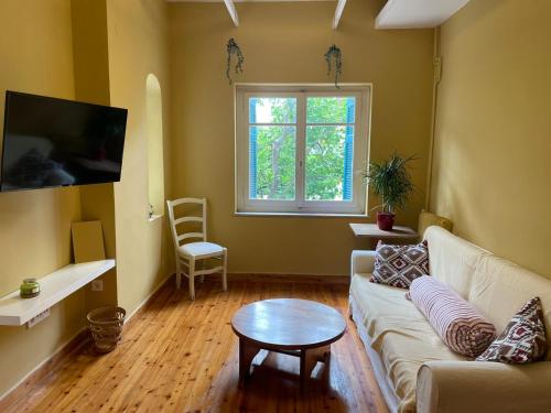 a living room with a couch and a table at Bluehouse with a garden in the city center in Mytilini
