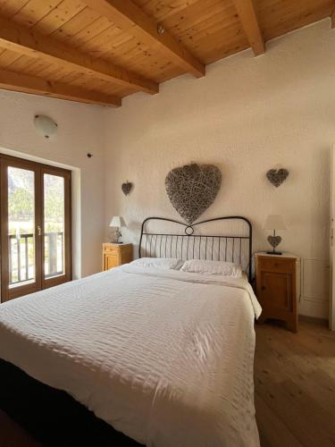 a bedroom with a bed with a heart on the wall at Chalet Giulia in Bezzecca