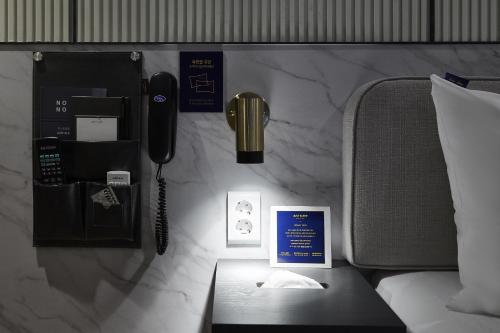 a phone on a wall next to a bed at Justsleep hotel Cheonan Dujeong branch in Cheonan