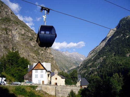 a cable car flying over a village in the mountains at Chalet Pitu - 1-6 People in Vénosc