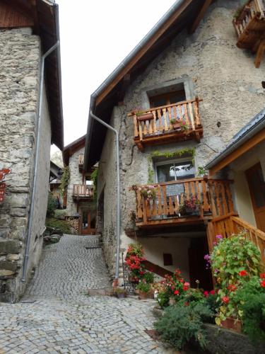 a stone building with a balcony and flowers on it at Chalet Pitu - 1-6 People in Vénosc