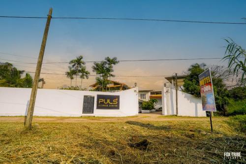 a building with a bus sign on the side of it at Riverside Hotel in Katunayake
