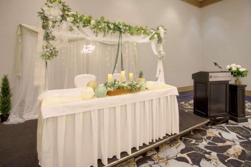 a table with a white altar with flowers and candles at Coast Chilliwack Hotel by APA in Chilliwack