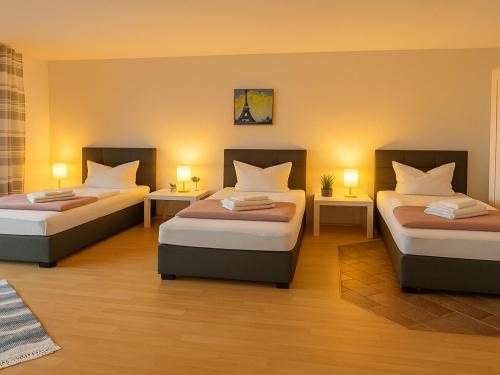 two beds in a room with two lamps on tables at SUNNYHOME Monteurwohnungen und Apartments in Schwandorf in Schwandorf in Bayern