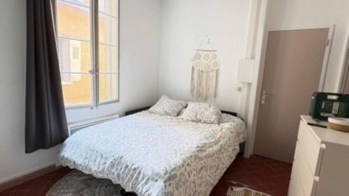 une petite chambre avec un lit et une fenêtre dans l'établissement L'harmonie de Saint Lazare 2, à Avignon