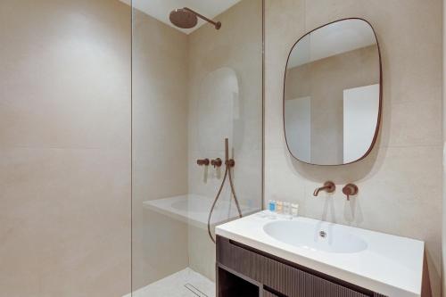 une salle de bain avec un lavabo et un miroir dans l'établissement 563 Suite Maillot - Superbe Appartement à Paris, à Paris