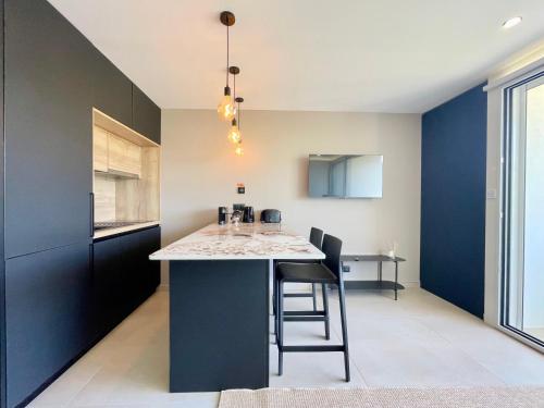 une cuisine aux murs bleus et une table avec des chaises dans l'établissement PGH N43 - Studio climatisé avec piscine, à La Grande Motte