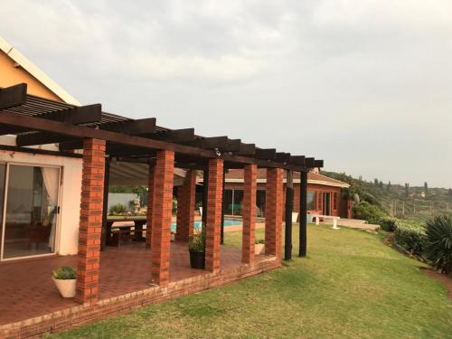 a brick patio with a pergola on a house at Platinum View Ocean Breeze in Widenham