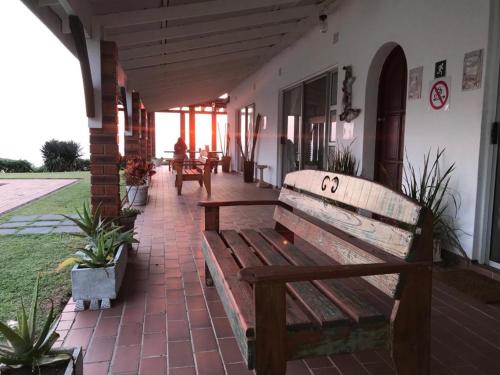 a wooden bench sitting on a patio with plants at Platinum View Ocean Breeze in Widenham
