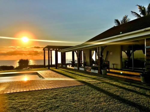 a house with the sunset in the background at Platinum View Ocean Breeze in Widenham
