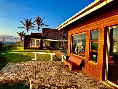 a brick house with a bench in front of it at Platinum View Ocean Breeze in Widenham