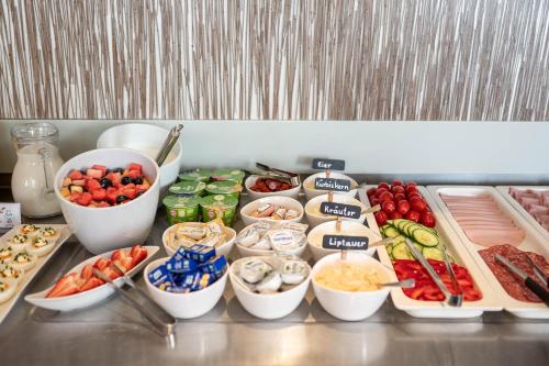 a buffet with different types of food in bowls at Hotel Ganslhof - Adults only in Salzburg