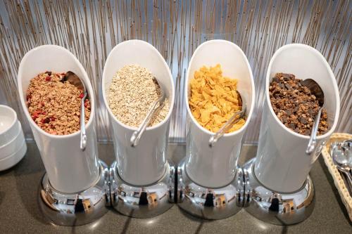 a group of four containers filled with different types of food at Hotel Ganslhof - Adults only in Salzburg