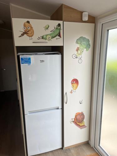 a refrigerator with stickers on it in a room at KPC-HELLYEAH caravan in Humberston