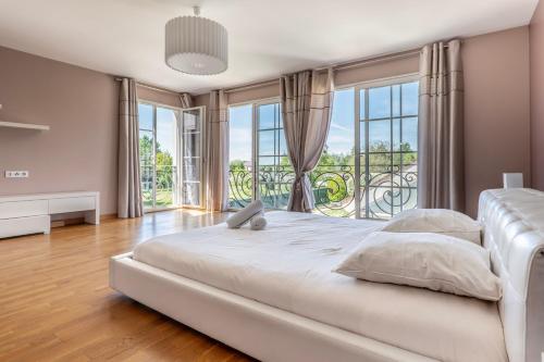 une chambre avec un grand lit avec une grande fenêtre dans l'établissement Disneyland Paris Maison de prestige, à Villeneuve-le-Comte