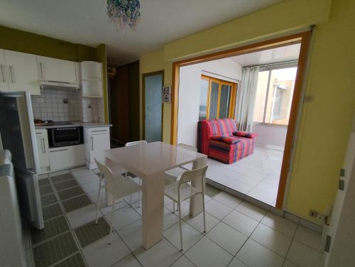 une cuisine et une salle à manger avec une table et des chaises dans l'établissement Appart en front de mer 1 chambre- parking -résidence le grand large, au Barcarès