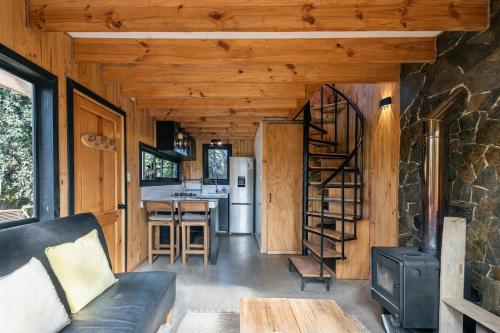 a living room with a couch and a spiral staircase at Casa full equipada Buchupureo in Buchupureo