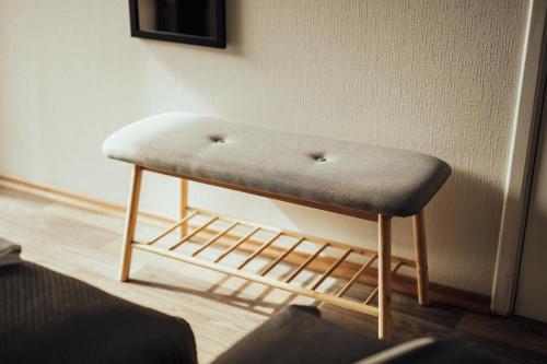 a ottoman sitting in the corner of a room at Brakši Namiņš in Pērkone