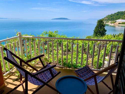 a balcony with two chairs and a view of the water at Podaca Holiday House with Sea View in Podaca