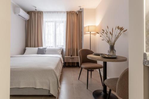 a hotel room with a bed and a table at The First Apart Hotel in Almaty