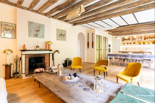 un salon avec une table et une cheminée dans l'établissement Beautiful villa view on garden and Paris Eiffel tower near transport Paris, à Meudon