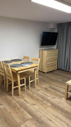 a dining room with a table and chairs and a flat screen tv at Dwunastka in Zakopane
