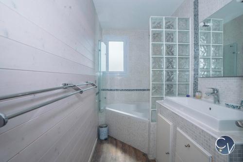 La salle de bains blanche est pourvue d'une baignoire, d'un lavabo et d'une baignoire. dans l'établissement Maison entière à 300m du centre, à LʼIsle-sur-la-Sorgue