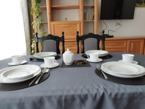 a table with plates and utensils on top of it at Silent Haven by Grafit in Legnica