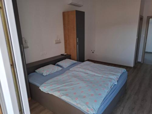 a small bedroom with a bed with blue sheets at MIRKO DIVING CENTER in Rab