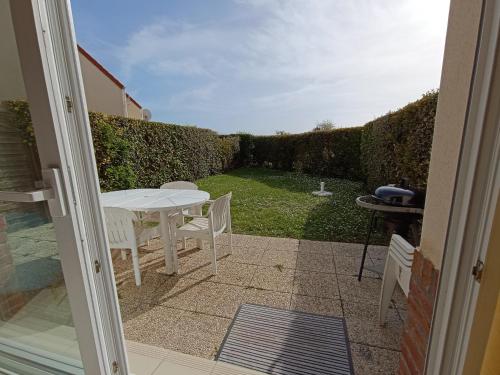 un patio con tavolo e sedie in un cortile di Au cœur de la baie de canche entre terre et mer a Étaples