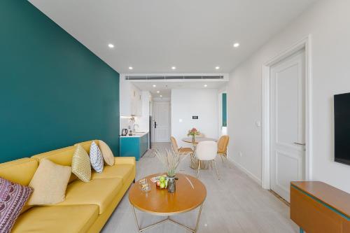a living room with a yellow couch and a table at La isla Apartments & Villas - Sea View & Fireworks Phu Quoc in Phu Quoc