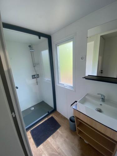 a bathroom with a shower and a sink and a mirror at Camping maeva Escapades Colomba in Olmeto