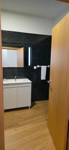 a bathroom with a sink and a tub and a mirror at Pôr do Sol II in Porto Moniz