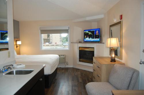 a hotel room with a bed and a sink at Vacation Lodge in Pigeon Forge