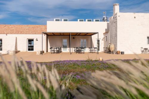 a building with a patio with tables and chairs at Masseria Vaccaro by Raro Villas - Self Check-in in Brindisi