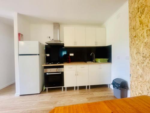 a kitchen with white cabinets and a black refrigerator at Casa do Sobreiro in Cantanhede