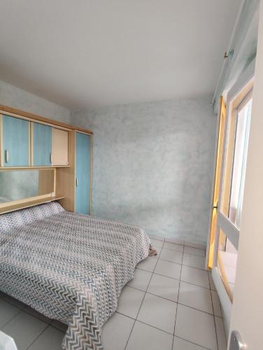 une chambre avec un lit et une fenêtre dans l'établissement Appart T2 en front de mer - chambre séparée -parking- terrasse couverte, au Barcarès