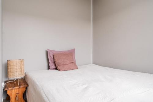 un letto bianco con due cuscini sopra di Comfy Top Floor Studio Apt in Centre of Helsinki a Helsinki