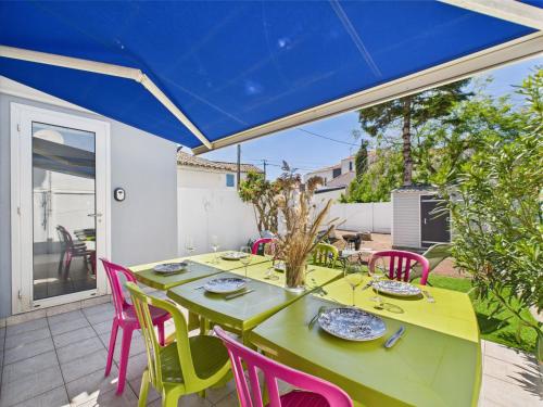 une salle à manger avec une table verte et des chaises roses dans l'établissement Entre coeur de ville et plage, maison pour 6, à Saint-Gilles-Croix-de-Vie