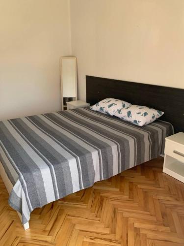 a bedroom with a bed and a wooden floor at Sunny in Split