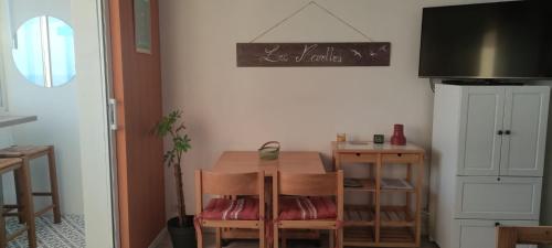une table et des chaises dans une cuisine avec un tableau noir au mur dans l'établissement studio FACE MER 85270 Saint Hilaire de Riez, à Saint-Hilaire-de-Riez