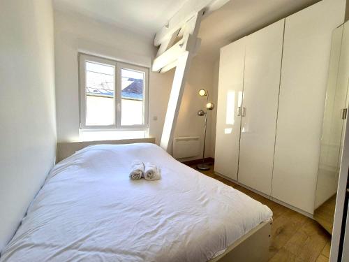 une chambre avec un lit avec deux chaussures dessus dans l'établissement Écu - 6 pers - Centre-ville - Lumineux, à Reims