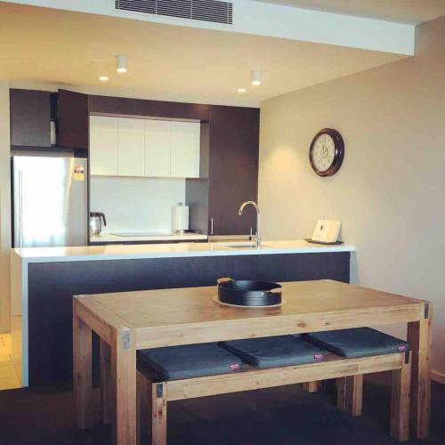 a kitchen with a wooden table and a sink at Prestige Waterfront Apartment in Kingston, ACT in Canberra