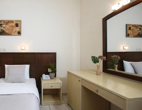 a bedroom with a bed and a large mirror at Hotel Astron in Kardítsa
