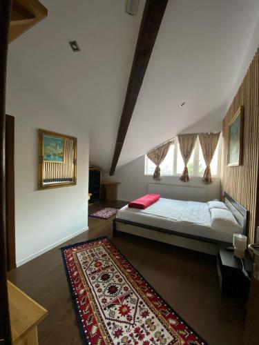 a bedroom with a bed and a rug at Pensiunea El Monte SPA in Rucăr
