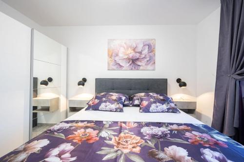 a bedroom with a bed with a floral bedspread at Tedoris Apartments in Srima