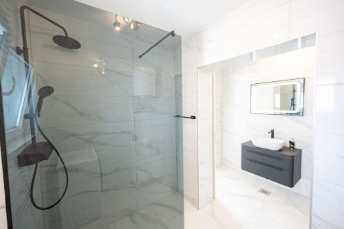 a white bathroom with a shower and a sink at Tedoris Apartments in Srima