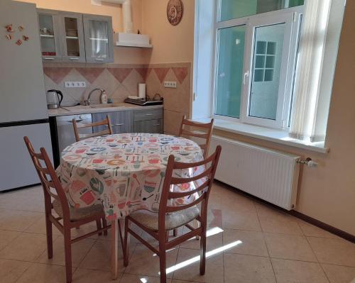 a kitchen with a table and chairs in a kitchen at Apartament Dzintari in Jūrmala