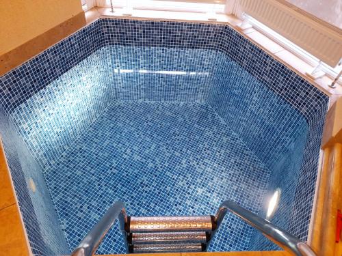 a swimming pool with a blue tile floor at Apartament Dzintari in Jūrmala