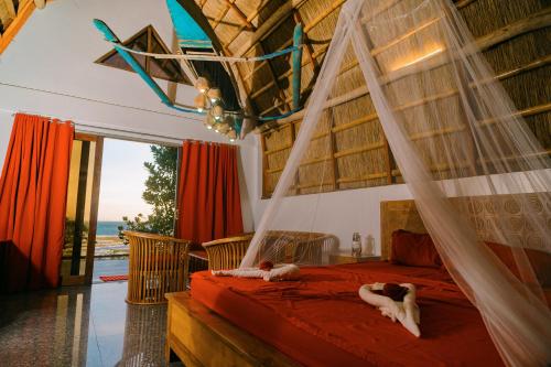 a bedroom with a hammock bed with two dogs laying on it at Butterfly Beach Resort in Taytay
